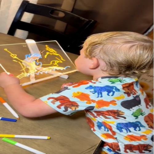 Child drawing on a glowing LED drawing board